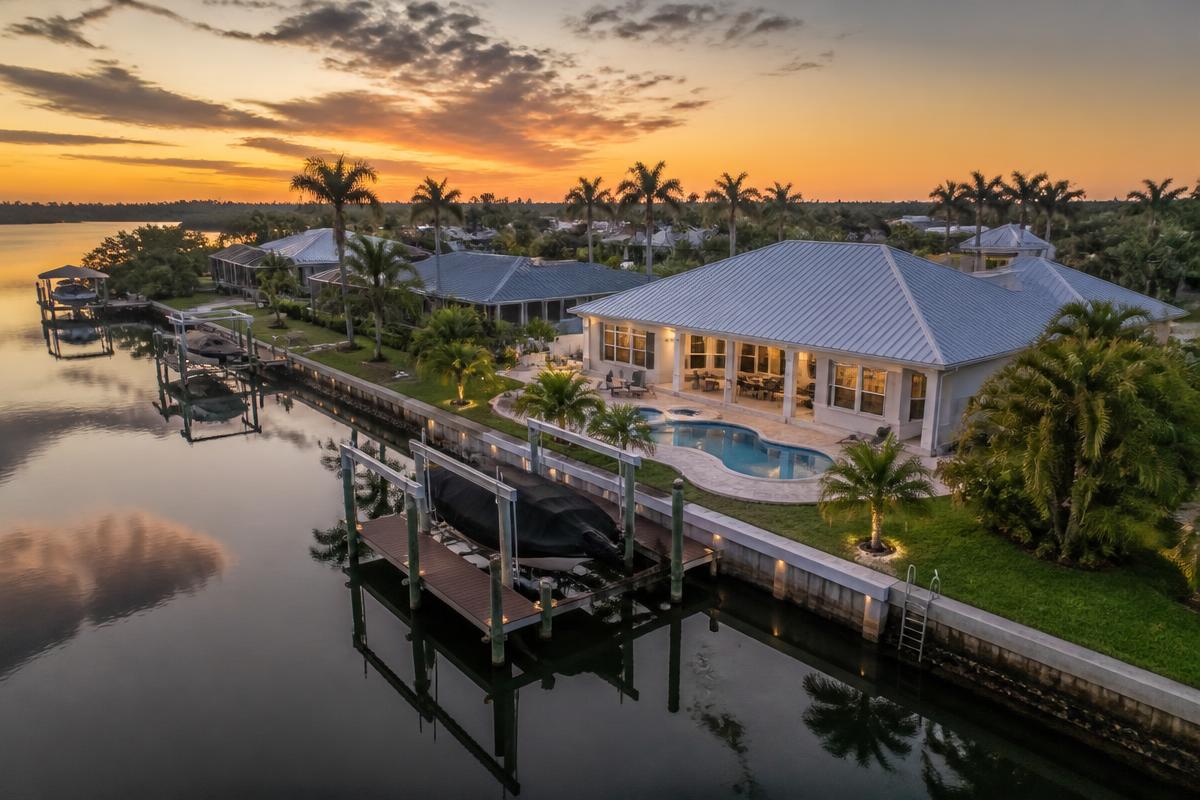 Aerial of a canal-front home with boat dock and seawall